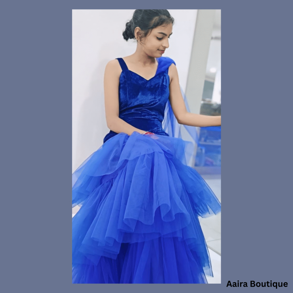 "Young woman in a vibrant royal blue tiered net gown from Aaira Boutique. Contact Aaira Boutique for this dress."